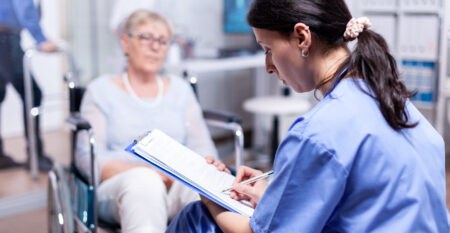 Nurse writing on clipboard